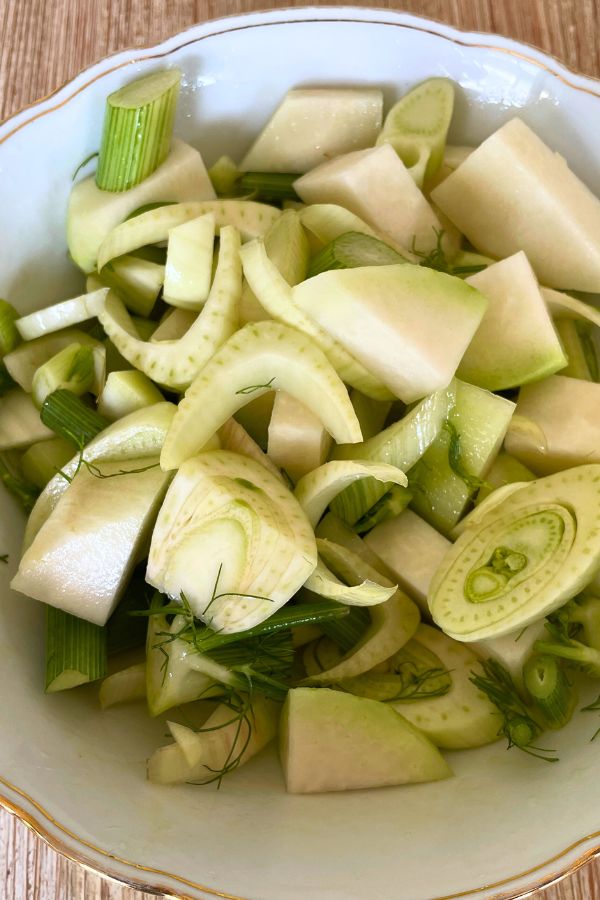 kleingeschnittener Kohlrabi und Fenchel in einer weißen, gold-verzierten Schale